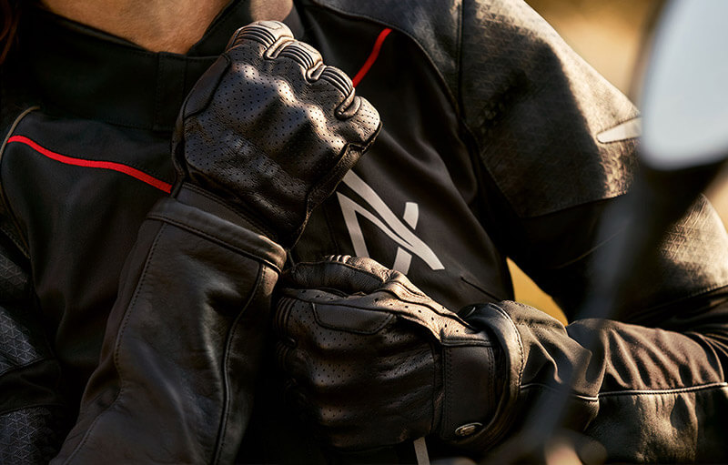 A Man Wearing the Suit and Summer Gloves and Pulling the Outserts over the Suit